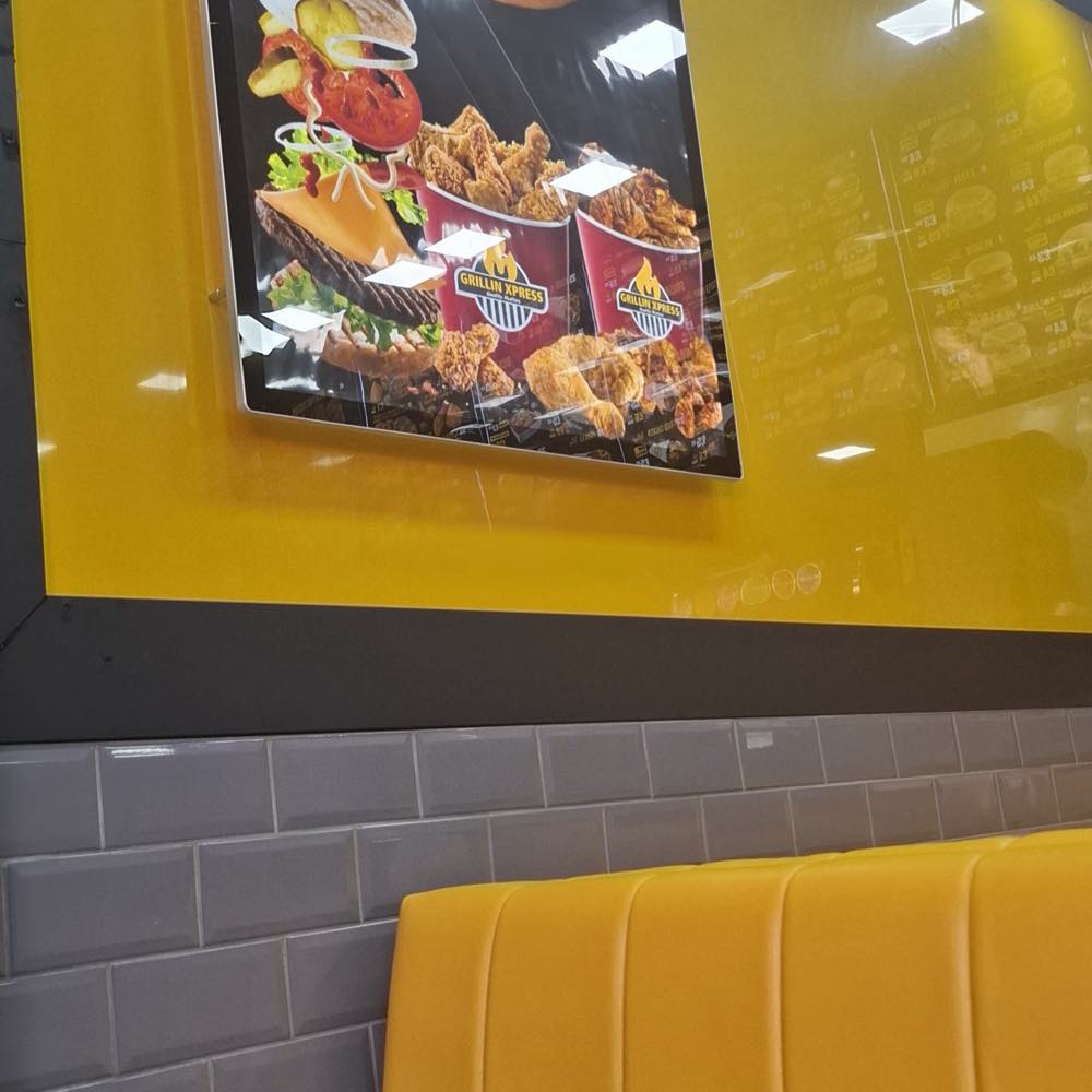 Yellow seating booth and food lightbox inside Grillin Xpress, Manor Park